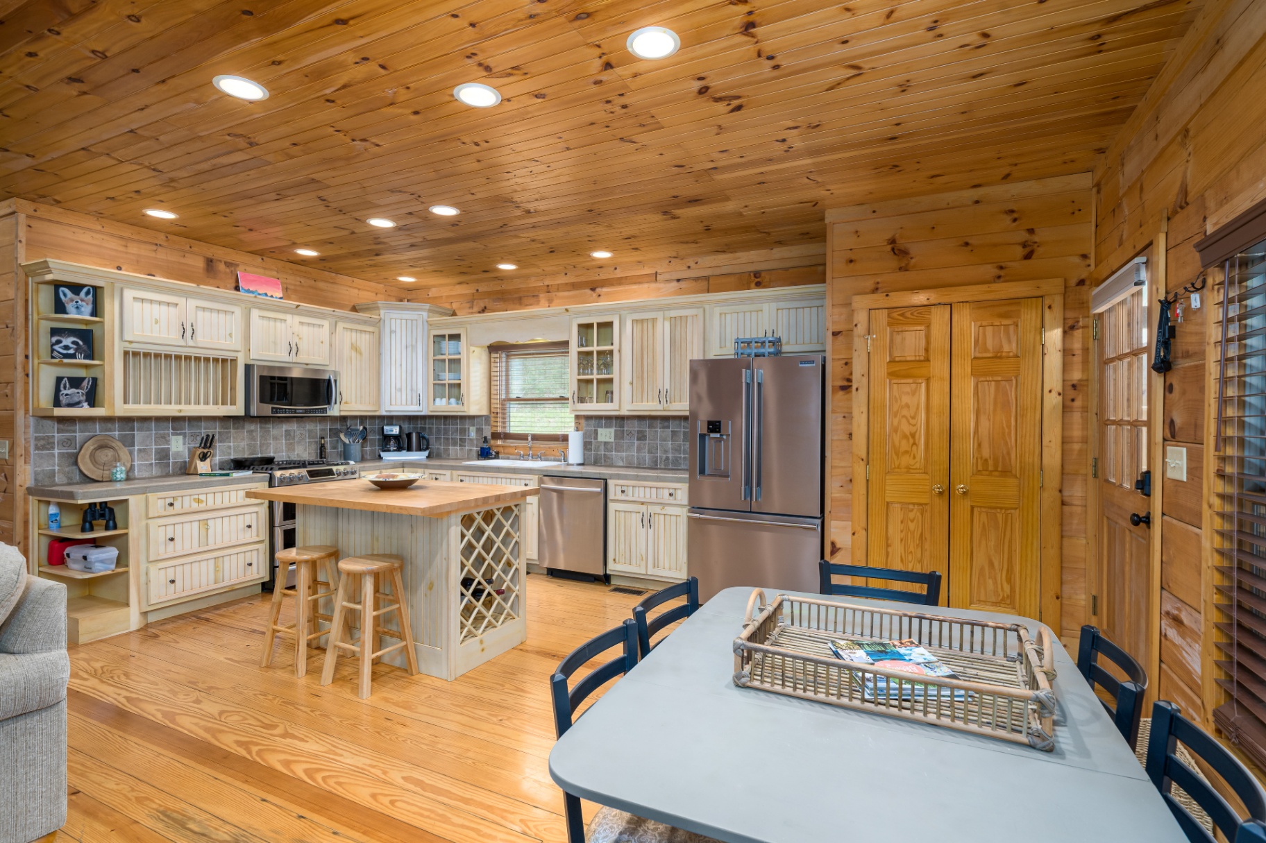 Chef's kitchen with butcher-block island, stainless appliances and bar seating