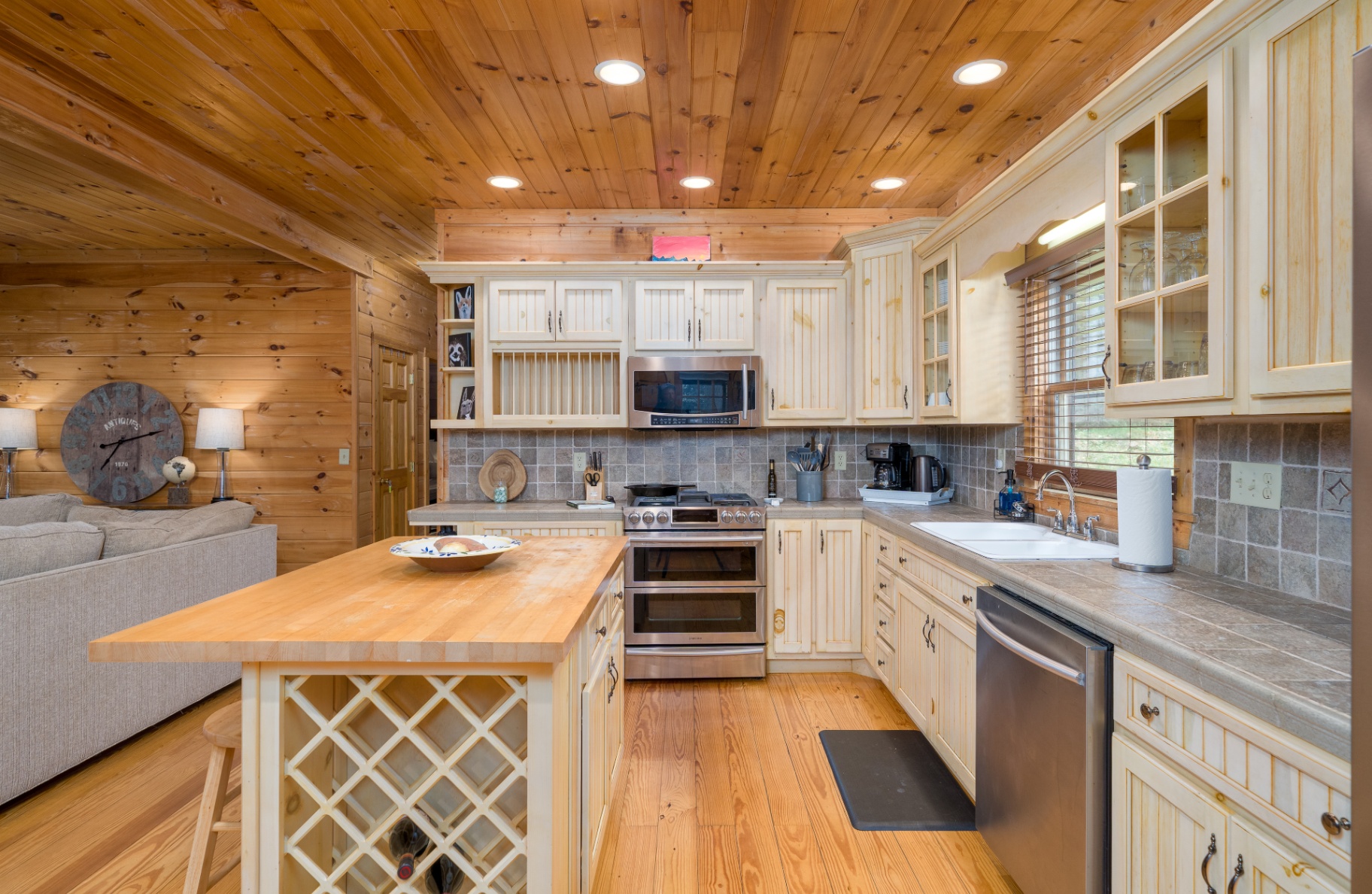 Kitchen island with gas range, wine storage and pine cabinetry
