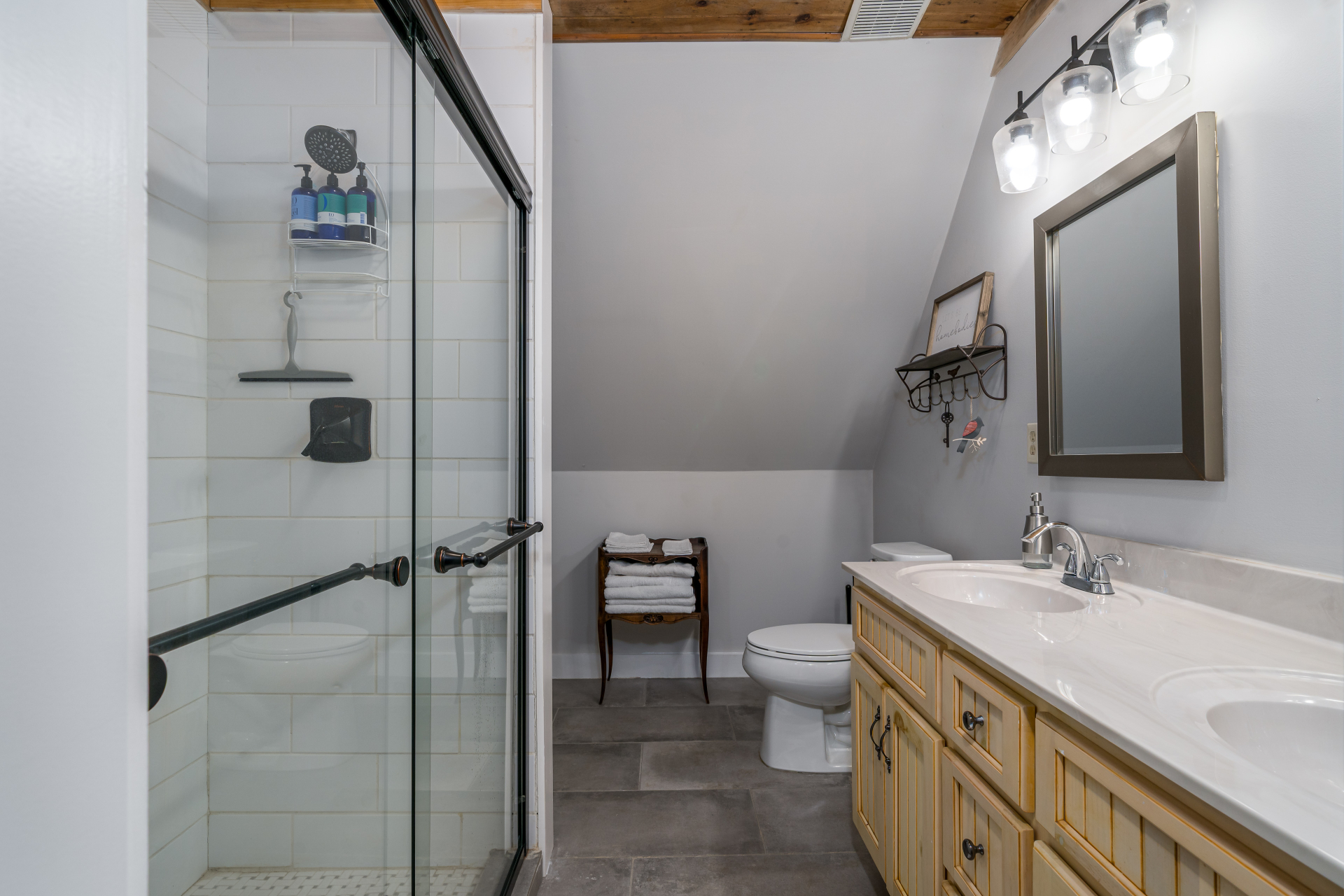 Upstairs bath with glass shower, double vanity and slate tile floor
