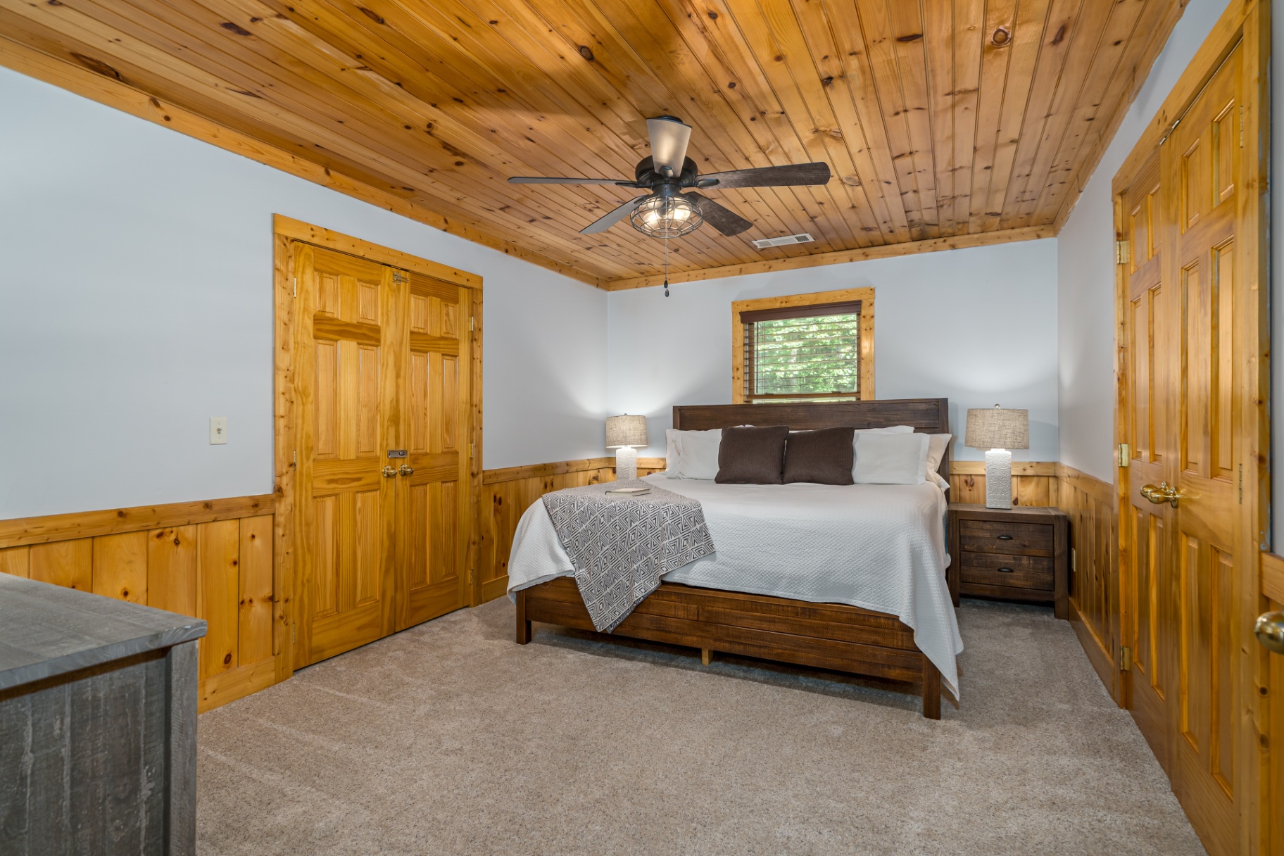 Guest king bedroom with wood ceiling, wainscoting and ensuite access
