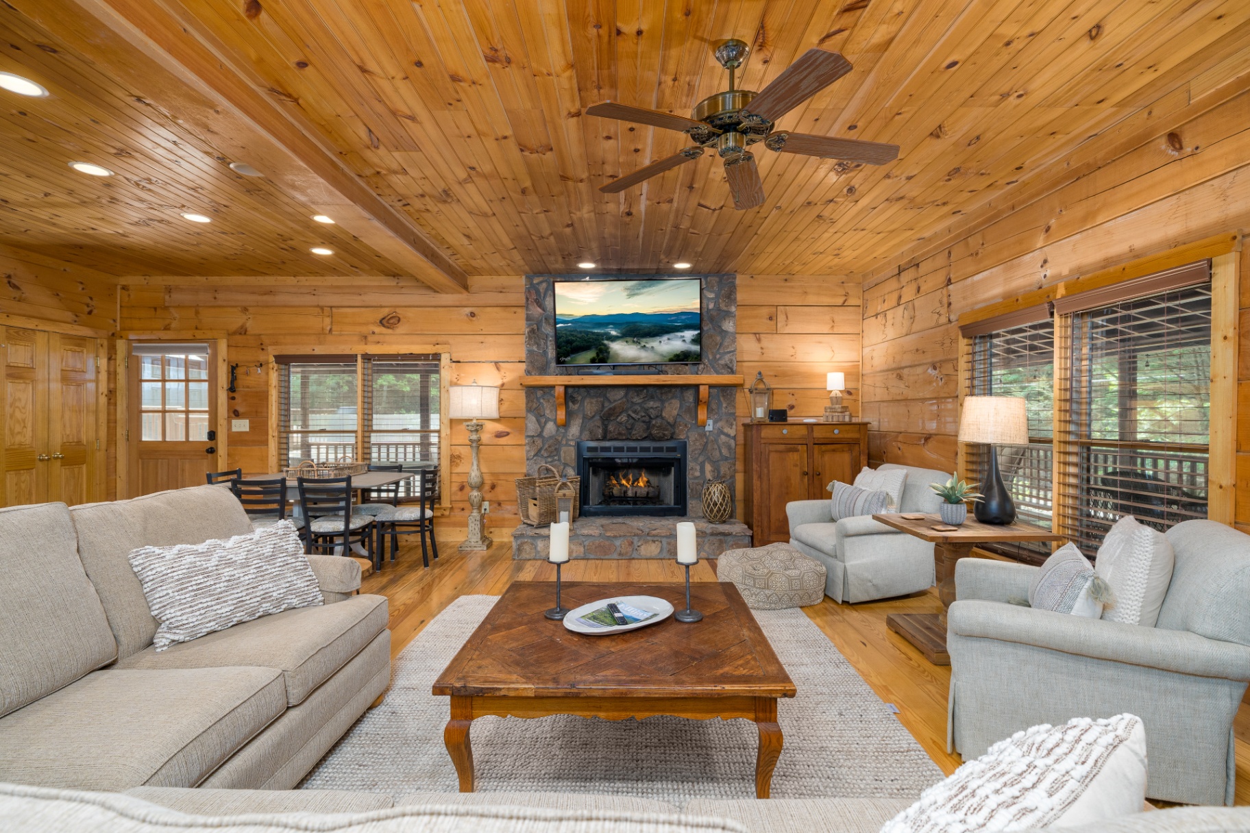 Wide view of the living and dining areas with fireplace centerpiece