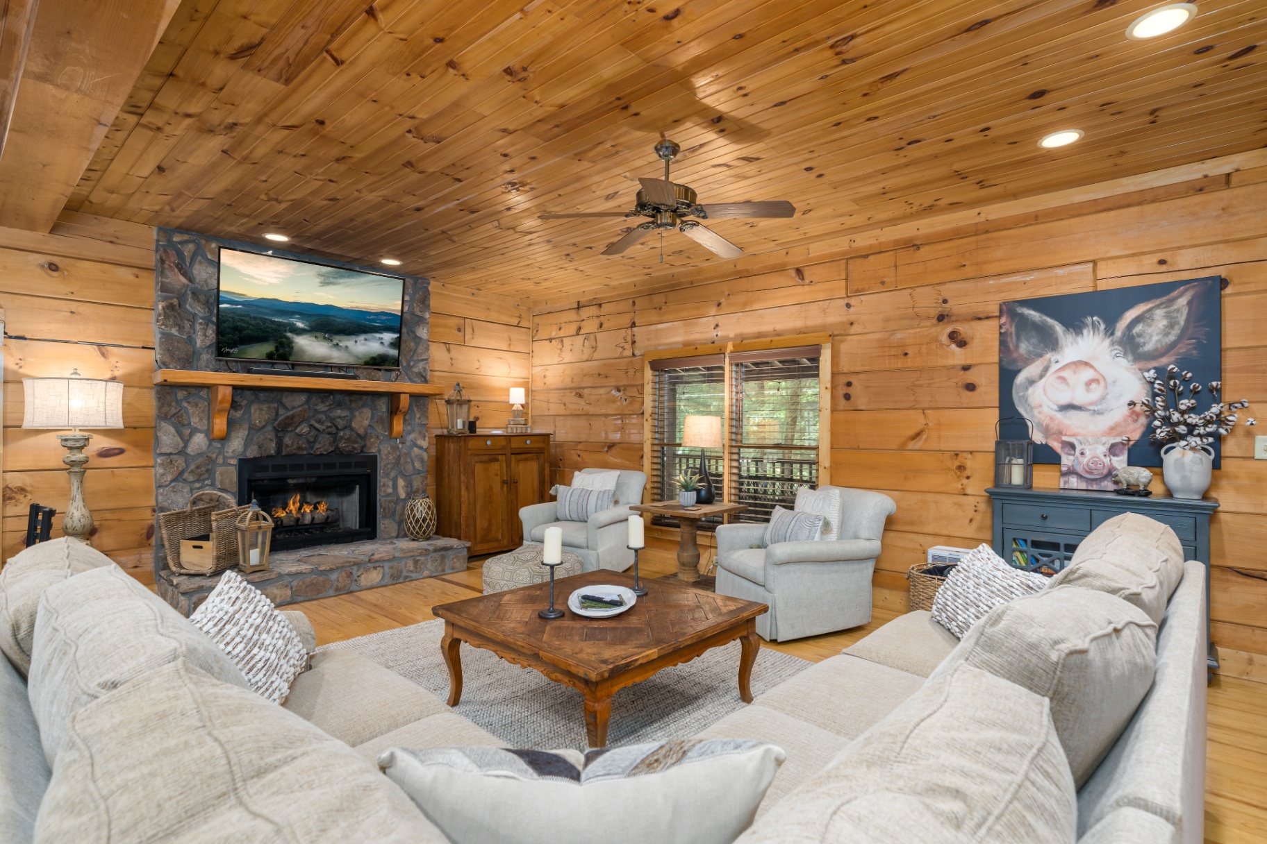 Great room with stone fireplace, mounted TV and cozy sectional seating