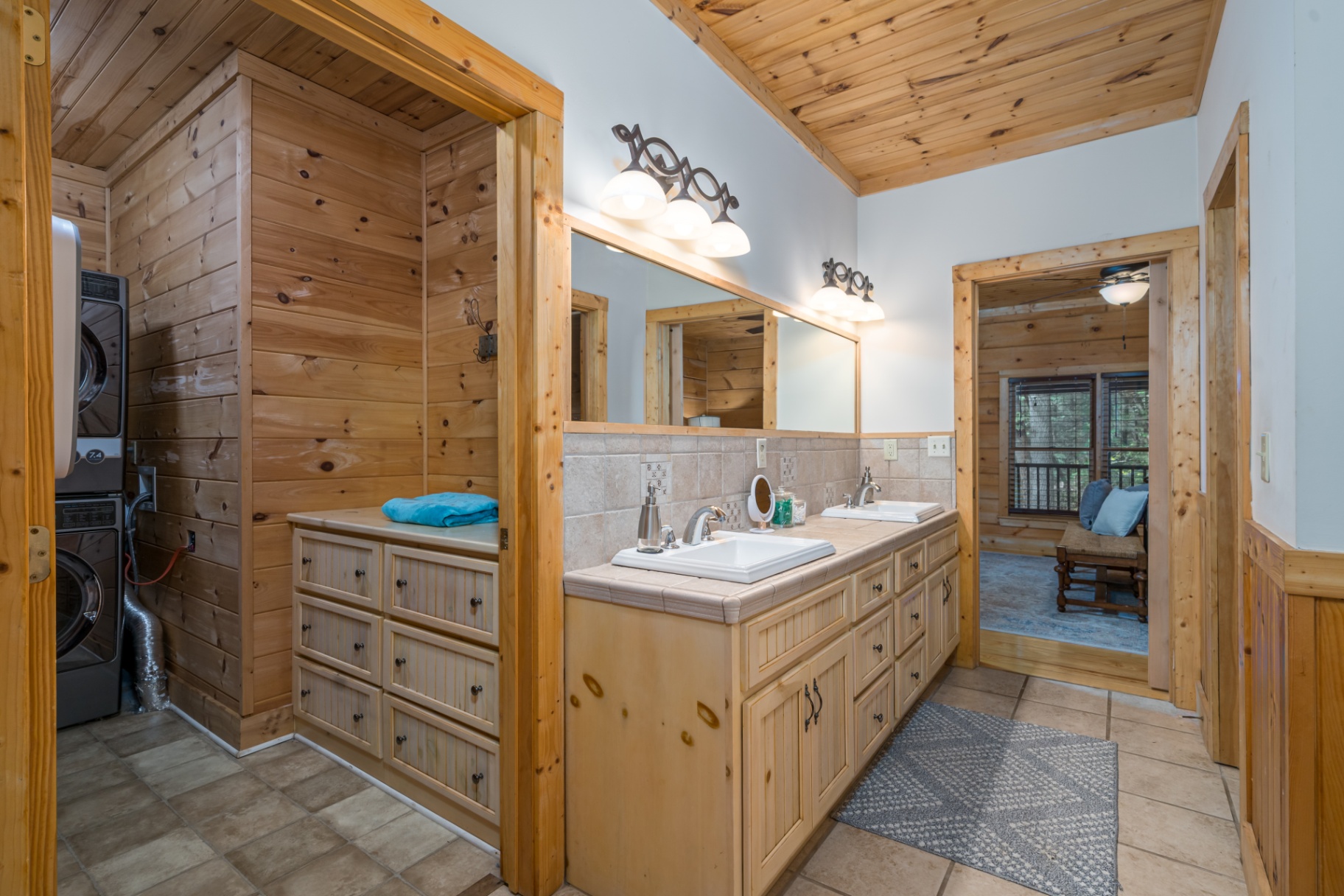 Bathroom with double sinks and stacked laundry area