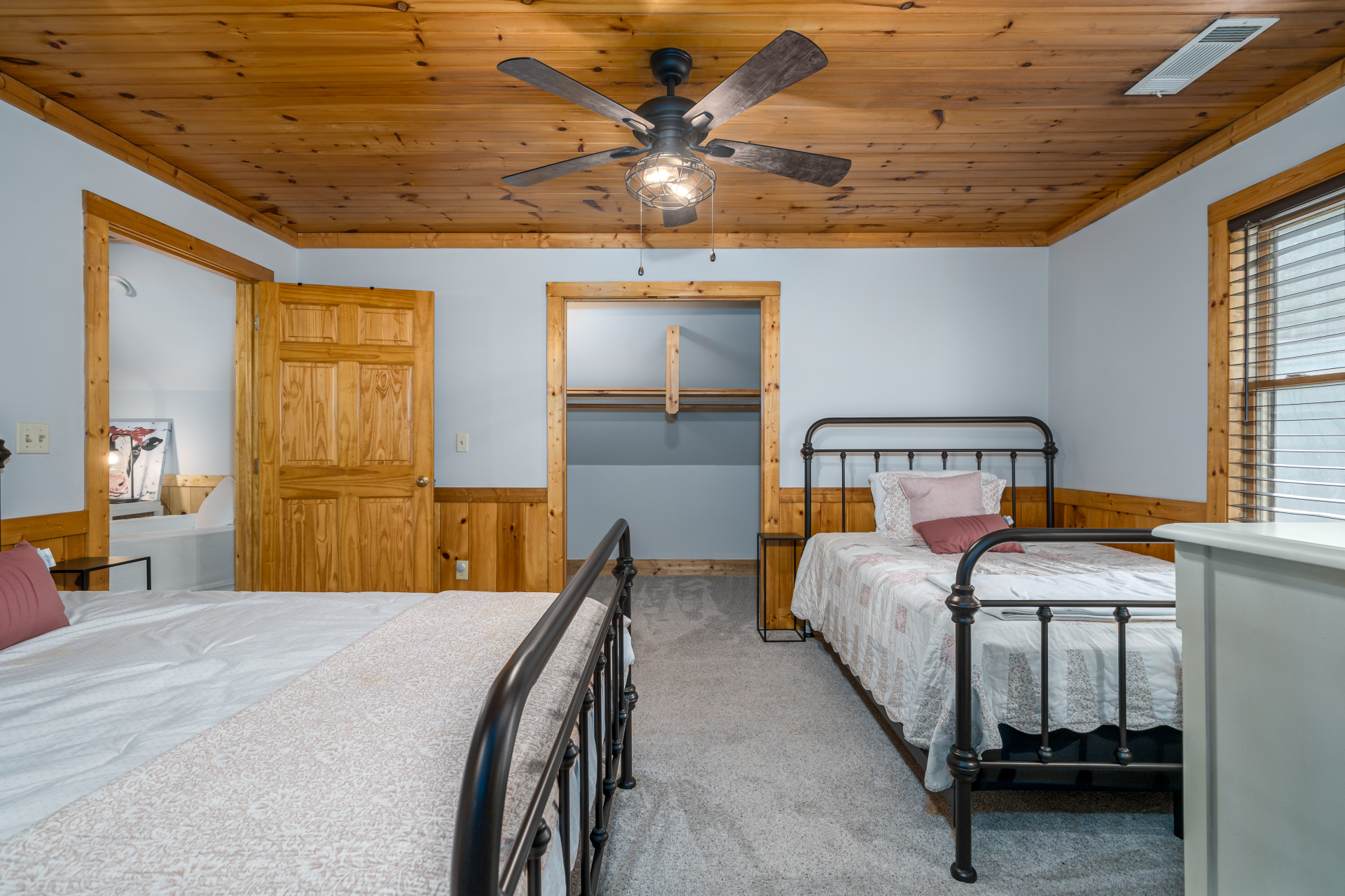 Guest bedroom with two full-size beds and pine ceiling