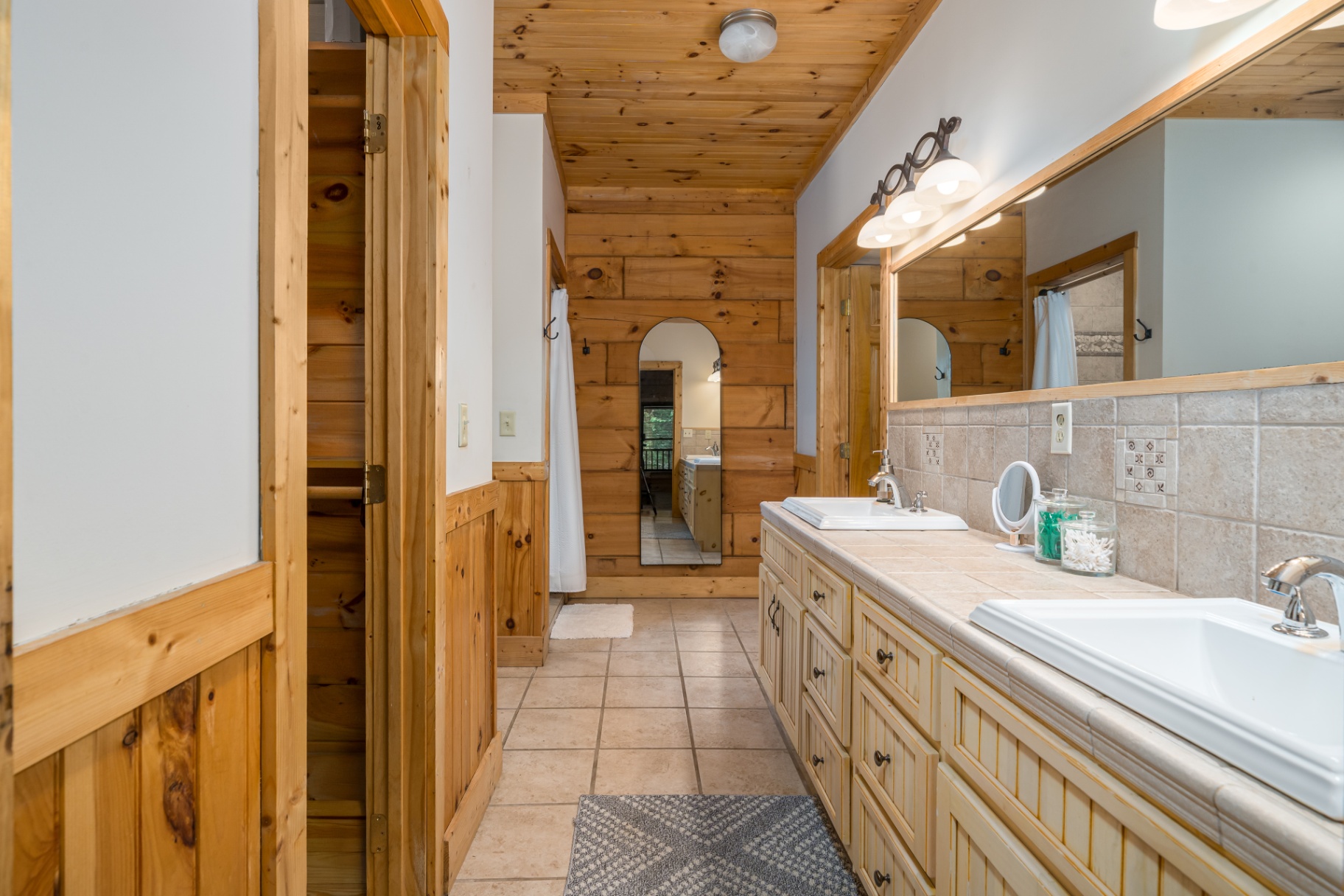 Ensuite bath with double vanity, tile floor and pine trim